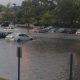 A flooded parking lot with cars parked in it.