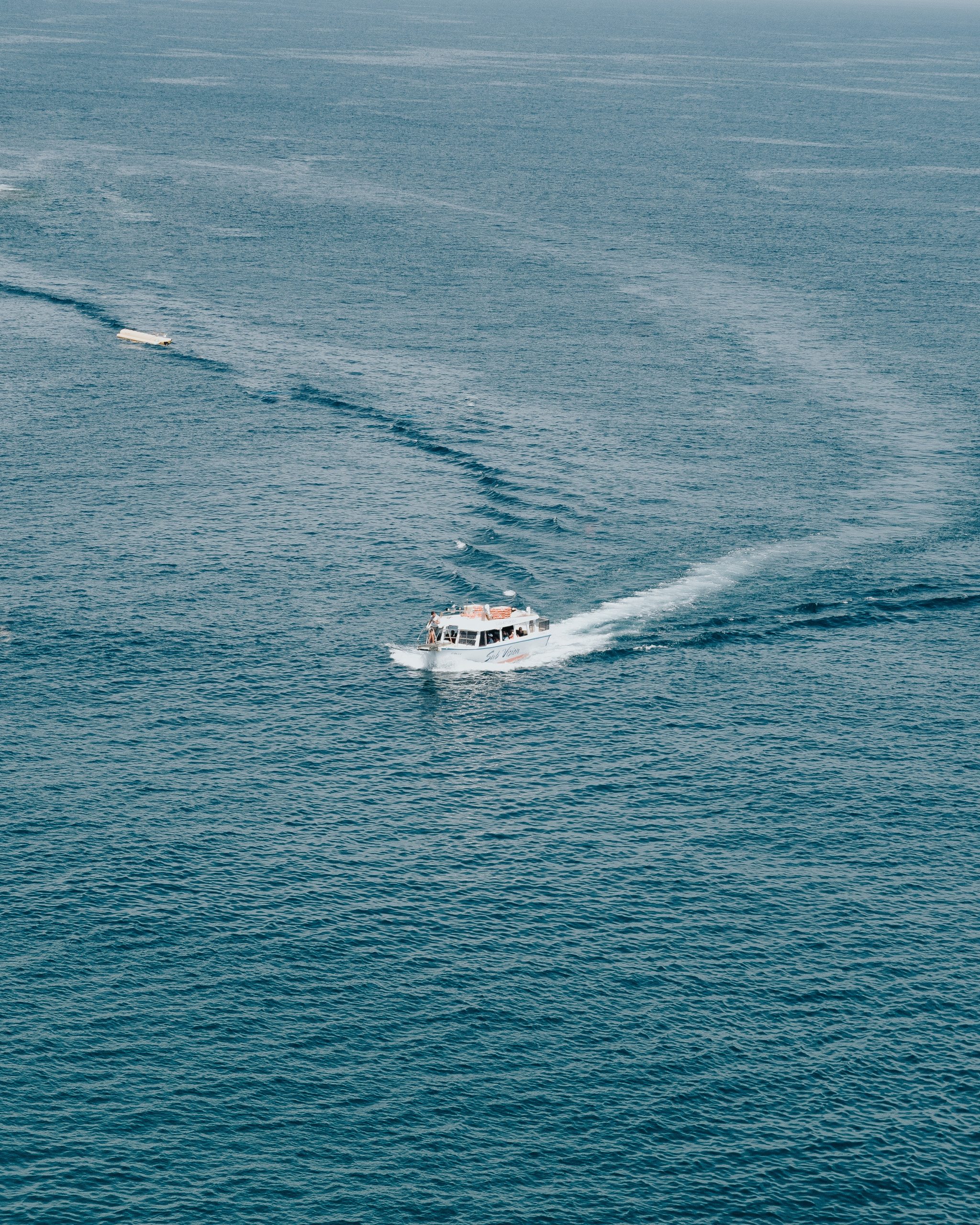 A boat is traveling through the water near some boats.