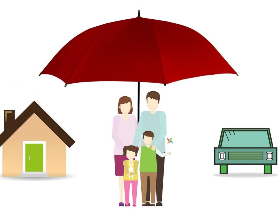A family under an umbrella in front of their home.