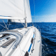 A boat sailing on the ocean under a blue sky.