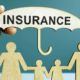 A person holding an umbrella over the word insurance.